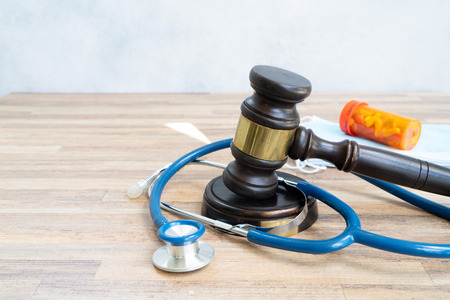 Healthcare law concept showing a judge’s gavel, stethoscope, and prescription medication, representing the intersection of healthcare and legal regulation.